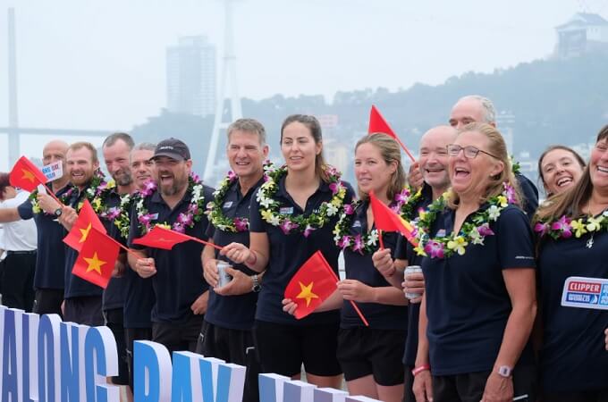 Les membres de l'équipe de voile saluent les spectateurs