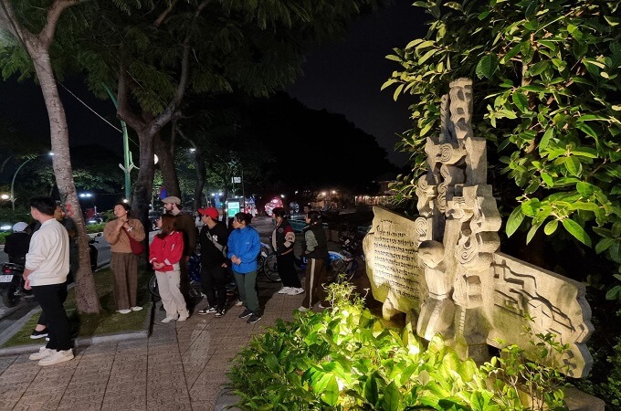 Les touristes s'arrêtent à côté de l'œuvre John McCain sur le lac Truc Bach