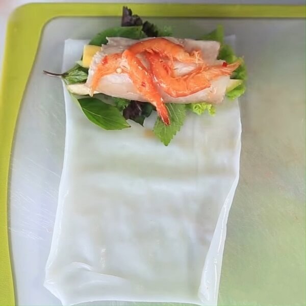 Placez une couche de papier de riz sur les feuilles de pho, appuyez doucement pour que la feuille de riz colle à la feuille de riz