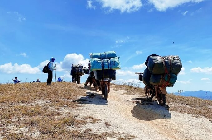 Les porteurs locaux portent les bagages des randonneurs en montée