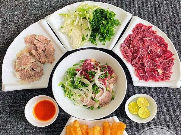 Le pho se mange chaud avec du citron frais et piment